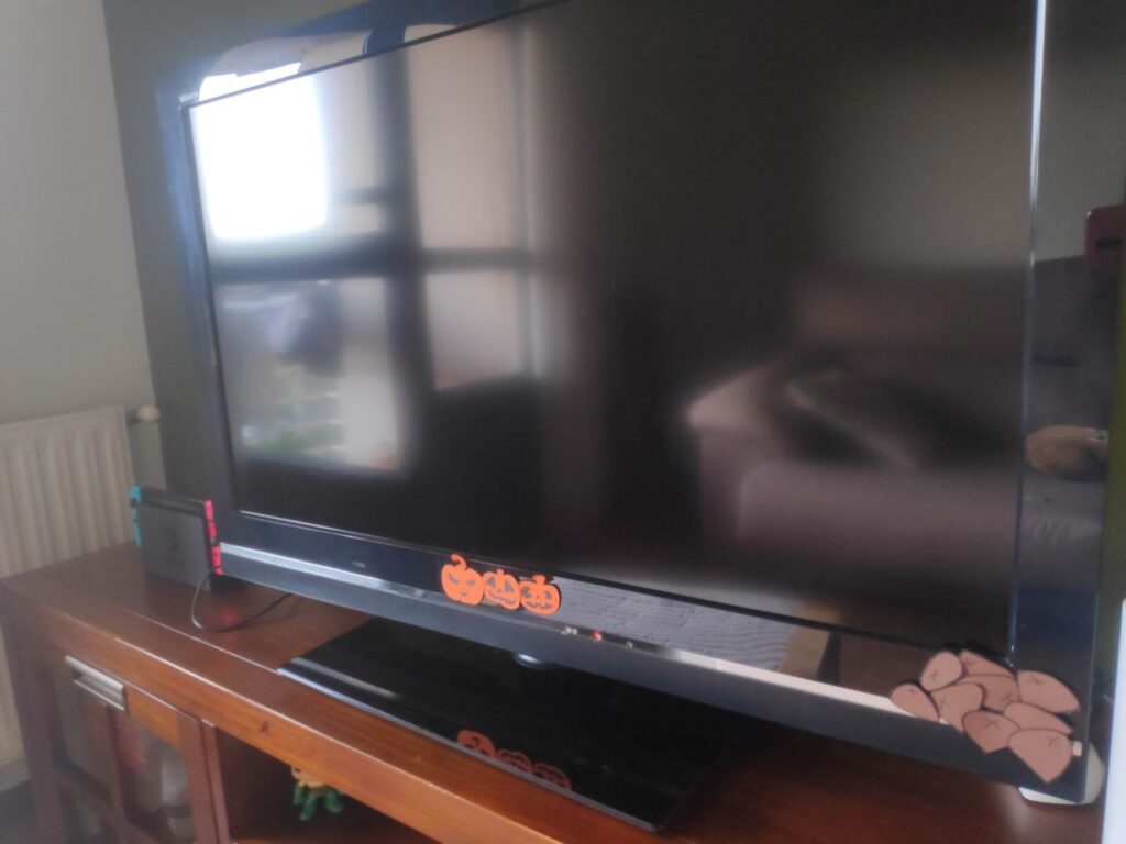 Foto de un televisor con cabaciñas e castañas de cartulina coladas pola marxe.
