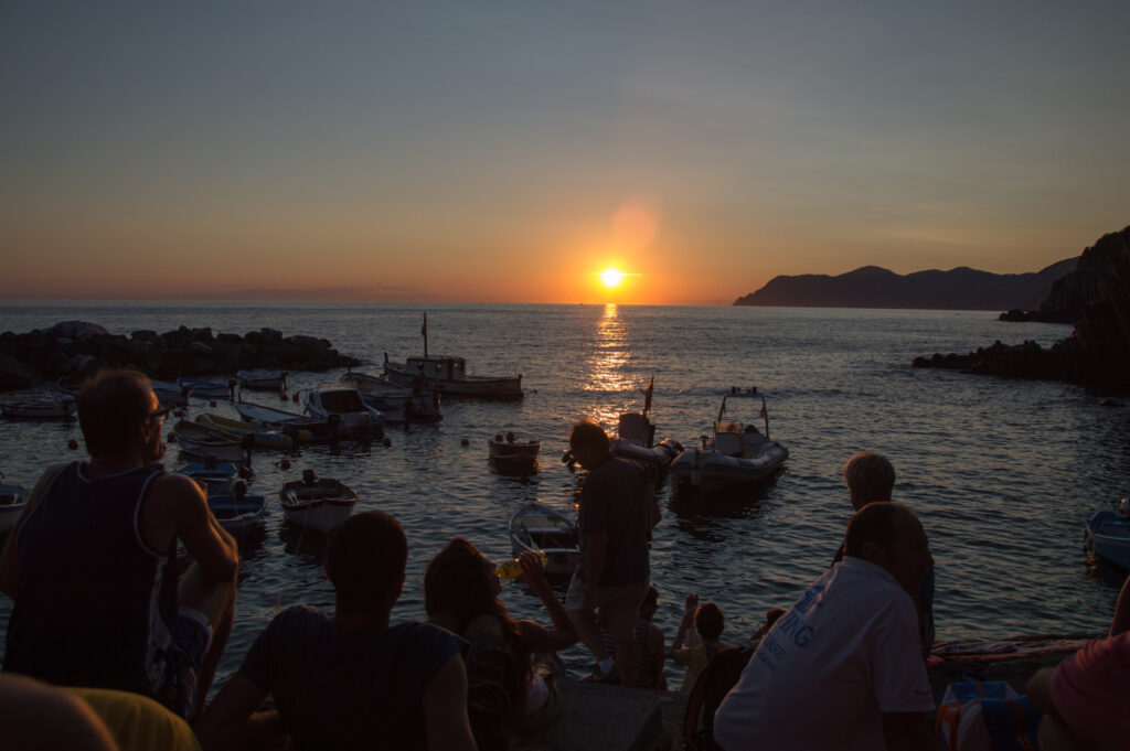Foto dun grupo de turistas vendo o solpor en Cinque Terre.
