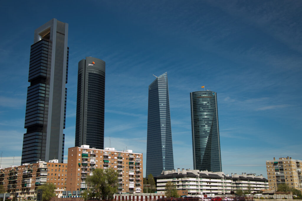 Foto de catro rañaceos contra un ceo azul.